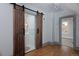Bedroom featuring plank floors and a bathroom with sliding barn doors for easy access and style at 482 S Logan St, Denver, CO 80209