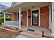 Inviting front porch with brick accents, white columns, and a cozy seating area at 482 S Logan St, Denver, CO 80209