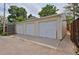 Spacious three-car detached garage with white doors and concrete driveway at 482 S Logan St, Denver, CO 80209