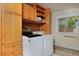 Bright laundry room featuring a washer, dryer, overhead cabinets, and natural light from the window at 482 S Logan St, Denver, CO 80209
