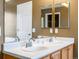 Bathroom featuring double sinks and vanity beneath a wide, well lit mirror at 5572 Kalispell St, Denver, CO 80239