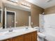 A well-lit bathroom with a dual sink vanity and a shower-tub combination at 5572 Kalispell St, Denver, CO 80239