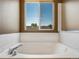 Close up of a bathtub with an adjacent window at 5572 Kalispell St, Denver, CO 80239