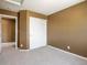 A bright bedroom with neutral walls, plush carpeting, and a closet for optimal storage at 5572 Kalispell St, Denver, CO 80239