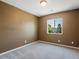 A cozy bedroom featuring neutral walls, plush carpeting, and a bright window for natural light at 5572 Kalispell St, Denver, CO 80239