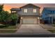 Charming two-story home with a two-car garage and well-maintained front yard at sunset at 5572 Kalispell St, Denver, CO 80239