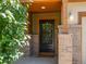 Inviting front door with brick columns and covered porch with a well-manicured shrub at 5572 Kalispell St, Denver, CO 80239