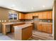 Bright kitchen featuring wood cabinets, a functional island, and natural light at 5572 Kalispell St, Denver, CO 80239