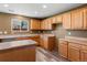Well-lit kitchen with light wood cabinets, wood-look flooring, and generous counter space at 5572 Kalispell St, Denver, CO 80239