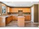 Bright kitchen with light wood cabinets, a functional island, and natural light at 5572 Kalispell St, Denver, CO 80239