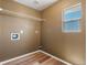 A functional laundry room with wood-look flooring and practical shelving for storage solutions at 5572 Kalispell St, Denver, CO 80239