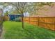 Spacious backyard featuring lush lawn, mature trees, and a secure wooden fence for privacy and play at 2838 Decatur St, Denver, CO 80211