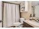 Cozy bathroom features a shower with curtain, toilet, sink, and bathroom cabinet at 2838 Decatur St, Denver, CO 80211