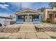 Charming blue duplex with a red tile roof and manicured front yard with stone landscaping at 2838 Decatur St, Denver, CO 80211