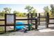 Dog park entrance with rules sign, water fountain, gate, and blue dog pool surrounded by wood fence and grassy fields at 2032 Oxford Ln, Superior, CO 80027