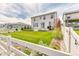 The well-manicured backyard features a new concrete patio and a grass area surrounded by a white fence at 6307 Saddle Bow Ave, Parker, CO 80134