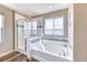 Bright bathroom features a soaking tub with decorative tile and a separate glass-enclosed shower at 6307 Saddle Bow Ave, Parker, CO 80134