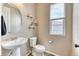 Cozy half bathroom featuring modern fixtures, vanity with sink, toilet and a window at 6307 Saddle Bow Ave, Parker, CO 80134