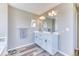 Modern bathroom featuring a double sink vanity, a large mirror, wood floors, and great lighting at 6307 Saddle Bow Ave, Parker, CO 80134