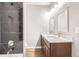 Modern bathroom featuring a double sink vanity with granite countertops and a sleek, black marble tiled shower at 530 Hickory St, Hudson, CO 80642