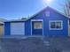 Charming blue home with an attached garage, bright exterior, and well-maintained gravel yard at 530 Hickory St, Hudson, CO 80642