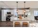 Modern kitchen with white cabinets, stainless steel appliances, granite countertops, and stylish pendant lighting over an island with seating at 530 Hickory St, Hudson, CO 80642