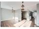 Spacious living room featuring hardwood floors, neutral gray walls, and stylish pendant lighting, connecting to a kitchen area at 530 Hickory St, Hudson, CO 80642