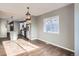 Bright living room with hardwood floors leading to a modern kitchen featuring stainless steel appliances and an island with seating at 530 Hickory St, Hudson, CO 80642