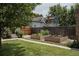 Landscaped backyard featuring garden beds, a green lawn, and a wooden fence for privacy at 461 S Sherman St, Denver, CO 80209