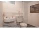 Basement bathroom featuring vintage sink and toilet with white walls and framed horse artwork at 461 S Sherman St, Denver, CO 80209