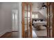 Spacious bedroom with a ceiling fan, stylish furnishings, and an ensuite bathroom, all accessed via a decorative wood door at 461 S Sherman St, Denver, CO 80209