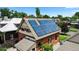 A two-story brick home fitted with solar panels on its roof amidst a lush, green neighborhood at 461 S Sherman St, Denver, CO 80209