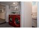 Laundry room with red washer/dryer, shelving, and a glimpse into an adjacent unfinished basement at 461 S Sherman St, Denver, CO 80209
