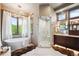 Bright bathroom featuring a standalone tub, glass shower, and mountain views at 16134 Sandstone Dr, Morrison, CO 80465