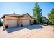 Spacious home featuring a three-car garage and stone accents, set against a clear blue sky at 16134 Sandstone Dr, Morrison, CO 80465