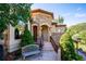 Inviting stone-clad entryway with arched porch, wooden bench, and landscaped surroundings at 16134 Sandstone Dr, Morrison, CO 80465