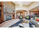 Living room with stone fireplace and view into kitchen area at 16134 Sandstone Dr, Morrison, CO 80465