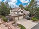 Picturesque aerial view of a two-story home with lush landscaping and a three-car garage at 5814 Cole Way, Arvada, CO 80004