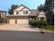Charming two-story home with a three-car garage, mature landscaping, and a brick facade at 5814 Cole Way, Arvada, CO 80004
