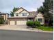 Charming two-story home with a manicured lawn, mature trees, and a three-car garage at 5814 Cole Way, Arvada, CO 80004