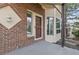 Covered porch with brick accents, a storm door, and exterior lighting at 5814 Cole Way, Arvada, CO 80004