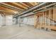 Unfinished basement offering potential with exposed ceiling, white plastic-wrapped walls, and concrete floor at 8785 Whiteclover St, Littleton, CO 80125