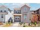 Charming gray two-story home featuring a covered porch and beautifully landscaped front yard at 8785 Whiteclover St, Littleton, CO 80125