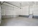 A clean, unfinished two car garage that features a side entrance with steps into the home at 8785 Whiteclover St, Littleton, CO 80125