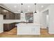 Spacious kitchen with an island, quartz countertops, and dark wood cabinets and stainless appliances at 8785 Whiteclover St, Littleton, CO 80125