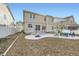 Back exterior view of a two-story home with a spacious patio, newly planted trees, and privacy fence at 5072 Cathay St, Denver, CO 80249