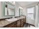 Bathroom featuring a double vanity, framed mirrors, and a window at 5072 Cathay St, Denver, CO 80249