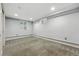 Clean basement featuring neutral carpet, ample lighting, and functional piping for potential customization at 2232 S Ogden St, Denver, CO 80210