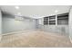 Basement with neutral carpet and built-in shelving, offering a versatile space for recreation or storage at 2232 S Ogden St, Denver, CO 80210