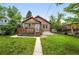 Charming brick home with a well-manicured front lawn and a wooden deck at 2232 S Ogden St, Denver, CO 80210